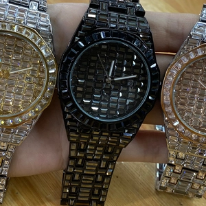 Detailed macro view of quartz watches with full square crystals in gold, black and silver