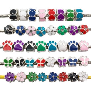 Close-up of colorful enamel charms in butterfly and heart shapes for DIY jewelry making