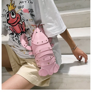 Detail of pink cartoon lobster bag featuring golden rivets and a slim chain shoulder strap