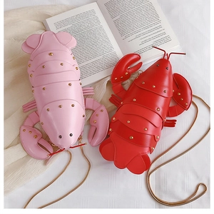 Detail of lobster shaped crossbody bags with metal chains and stud embellishments
