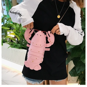 Detail of pink lobster crossbody bag featuring golden rivets and a fine metal chain strap