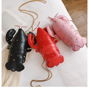 Detailed close-up of cartoon lobster crossbody bags in black, red, and pink colors