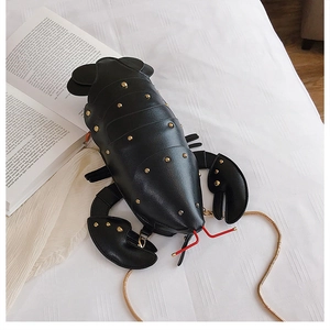 Detailed view of the 3D lobster-shaped crossbody bag featuring golden stud accents