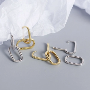 Detailed view of polished S925 sterling silver oval hoop earrings in gold and silver finish