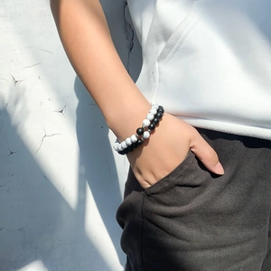 Detail of magnetic stone bracelets for couples featuring white marble and matte black beads