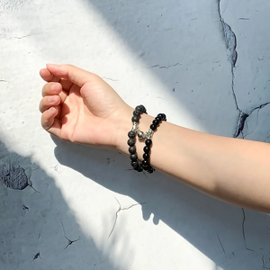 Detailed view of couples' magnetic bead bracelets with lava stone and black agate beads