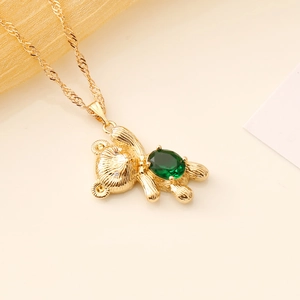 Golden bear necklace with a large green oval gemstone pendant on a twisted chain
