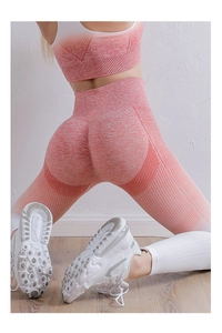 Close-up of seamless orange gradient leggings showing ribbed texture and mesh details