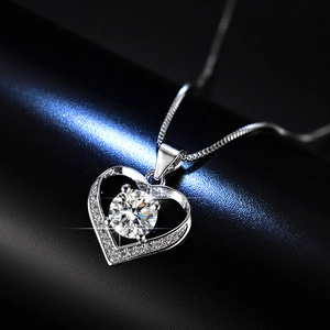 Close-up of heart pendant with floating moissanite stone and side diamond accents