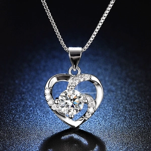 Macro shot of silver heart pendant with brilliant central stone and pavé setting details