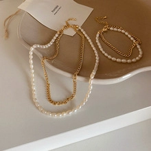 Dettaglio del set collana di perle barocche e bracciale dorato a strati