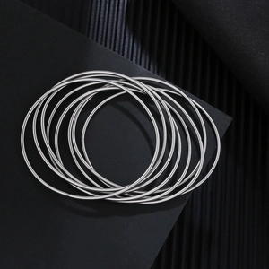 Detailed top view of 1.7mm stainless steel wire bracelets on a textured black background