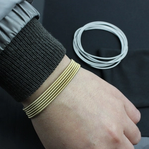 Detail of 1.7mm stainless steel spring bracelets in gold and silver finish on wrist