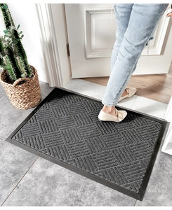 Close-up of non-slip rubber door mat with woven geometric texture in a home setting