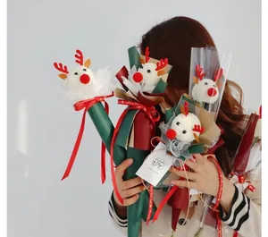 Close-up of reindeer-shaped Christmas flower bouquets with cute antlers and Merry Christmas ribbons
