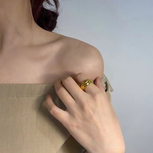 Close-up van een dikke minimalistische vergulde koepelring aan de vinger van een model