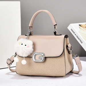 Detail of beige woven texture bag with crystal G buckle and plush monster charm