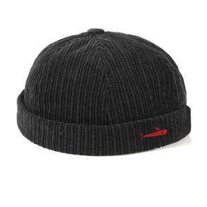Close-up of black corduroy brimless docker hat featuring unique red fish embroidery