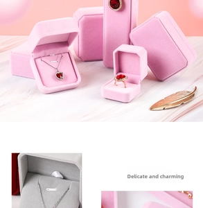 Pink and grey velvet jewelry boxes for rings and necklaces on marble background