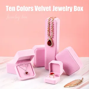 Elegant pink velvet jewelry boxes for rings and necklaces on marble surface