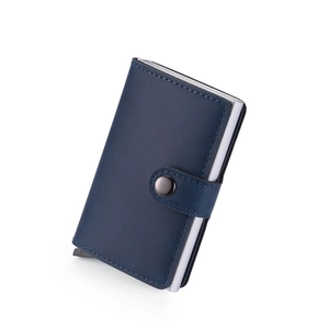 Detail of navy blue leather card holder showing the silver aluminum pop-up card mechanism