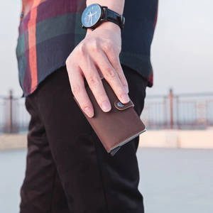 Brown leather automatic pop-up card holder with metal shell and snap button closure