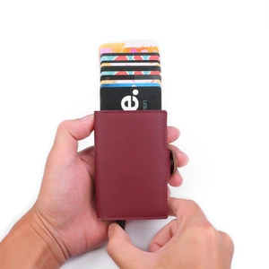 Detail view of burgundy leather pop-up card holder with side metal slide button mechanism