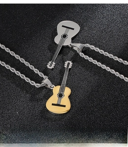 Detail of gold and silver guitar pendant necklaces with textured rope chain on black surface