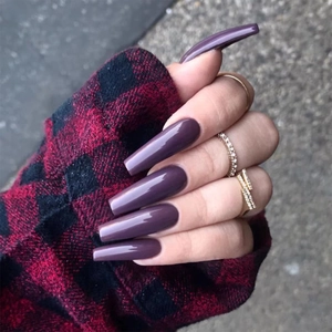 Detailed close-up of glossy deep mauve long ballerina coffin press-on nails