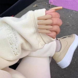 Long ballet coffin shape press-on nails in matte nude finish shown in hand photo
