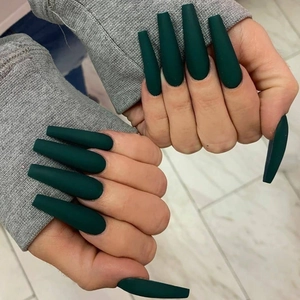 Detailed view of matte dark green long coffin press-on nails shown on hands