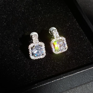 Exquisite square halo stud earrings with round center stone and pave setting on black velvet