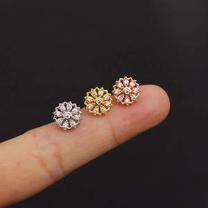 Three zircon flower stud earrings in silver, gold, and rose gold finishes on black background