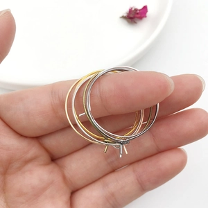 Macro detail of DIY metal earring hoops in gold, silver, and rose gold finishes