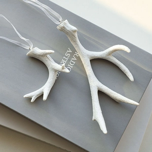 White resin reindeer antler ornaments set with ribbons for minimalist Christmas tree decor