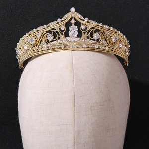 Detailed view of a golden bridal tiara with sparkling white rhinestones on a display head