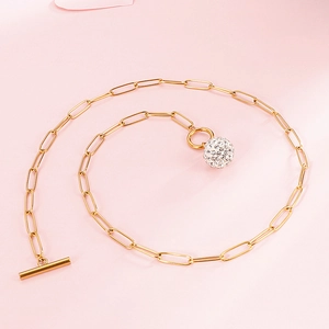 Golden link chain necklace with crystal sphere pendant and T-bar toggle clasp on pink background