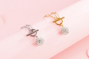 Detail view of silver and gold OT clasp bracelets with shimmering rhinestone spheres