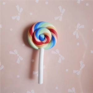 Gros plan sur une sucette arc-en-ciel en pâte polymère pour pinces à cheveux et DIY