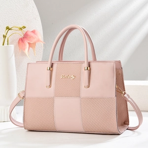 Detail of light pink handbag showing textured stitching and golden Danbaoly logo