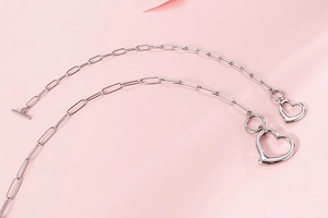 Detail view of silver paperclip chain with heart pendants and OT toggle closure