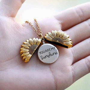 Detail of opening golden sunflower locket revealing You Are My Sunshine engraving