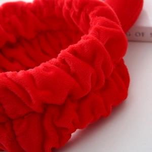 Gros plan du bandeau en peluche rouge avec tissu élastique et texture douce