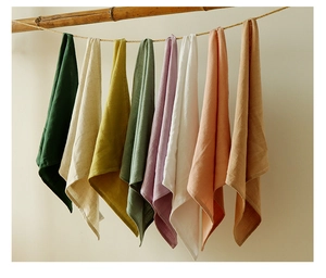 Variety of waffle weave cotton linen tea towels in eight vibrant colors on a wooden rack