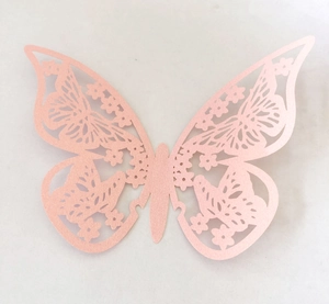 Detail of pink laser-cut 3D butterfly wall sticker with intricate hollow floral patterns