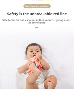 Infant holding a soft coral baby security blanket with colorful textured sensory tags