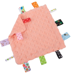 Pink dotted minky baby security blanket with colorful sensory ribbon tags on white background