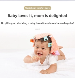 Pink textured baby security blanket with colorful sensory tags on a clean white background
