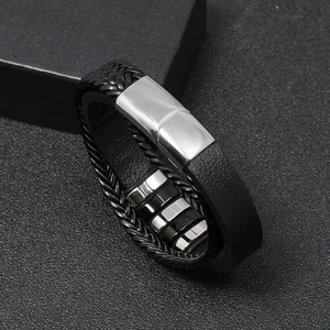 Close-up of braided black leather men's bracelet with a polished stainless steel clasp
