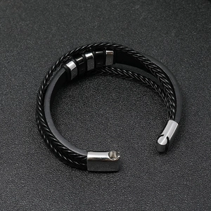 Close-up of men's layered leather bracelet with stainless steel clasp and woven texture